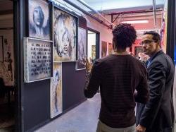 MFA Student and Faculty discussing artwork on display