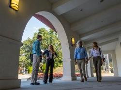 Students walking around near the amphitheater and Kasser Theater.