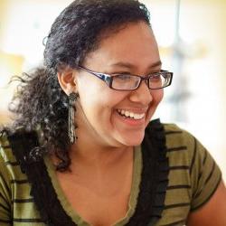 Young woman with with brown hair and glasses smiling