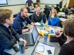 Team of students at a table in experiential classroom