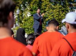 Montclair State University President Jonathan Koppell addressing students in red shirts from the sitting area at the top of the quad near Russ and Chapin halls