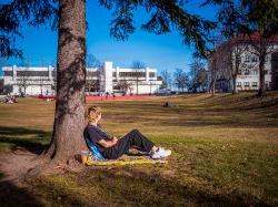 Student on the campus quad, looking away from camera (face not visible)