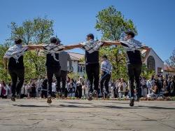 Students link arms in a dance.