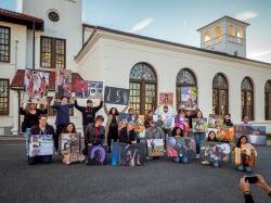 Students Holding Photojournalism Project Photos outside of School of Communication Building