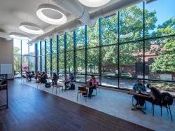 Students sitting in the dining area of the Student Center with giant windows.