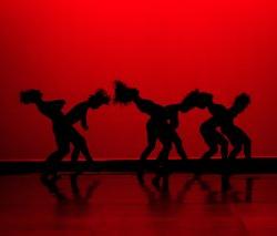 dancing silhouettes in front of piercing red background